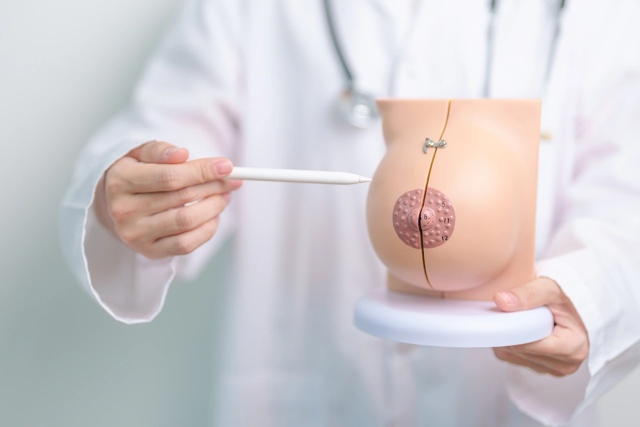 Doctor demonstrating the difference between textured and smooth silicone implants for breast surgery.